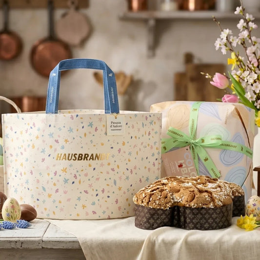Colomba pasquale Hausbrandt con shopping bag decorata e confezione regalo su tavolo rustico