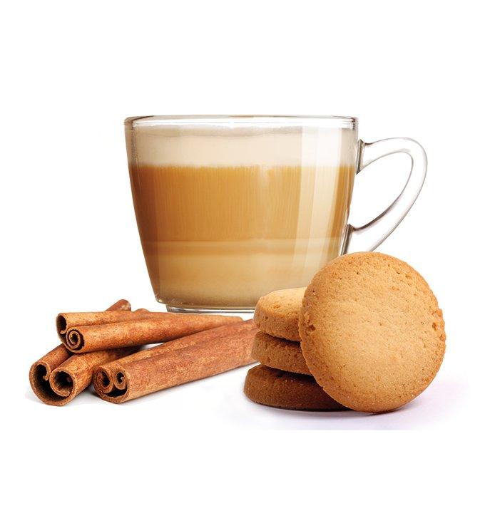 Tazza di caffè con panna, biscotti al cannella impilati e stecche di cannella su sfondo bianco