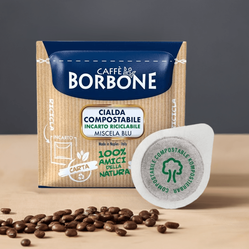 Confezione Caffè Borbone Miscela Blu con cialda compostabile e chicchi di caffè su fondo beige